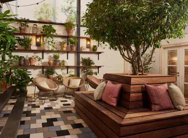 Stylish meeting space in The Hoxton, Amsterdam with greenery and cozy seating.