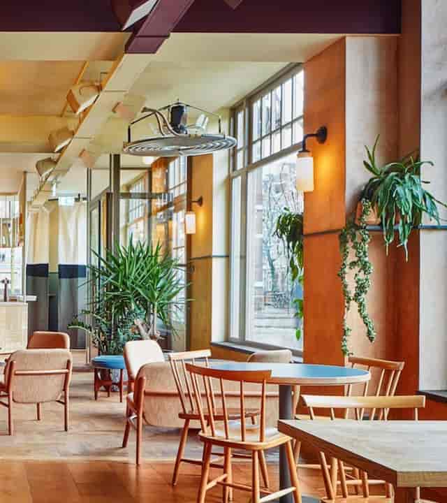 Modern event space in Karavaan Amsterdam with natural light and greenery for meetings.