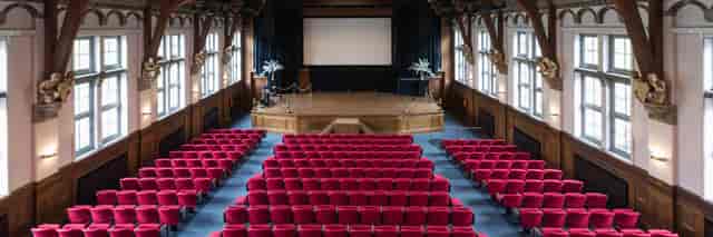 Queen Maxima Hall auditorium with red seating, perfect for conferences and seminars.