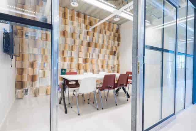 Modern meeting room in B. Amsterdam with textured wall for workshops and brainstorming sessions.