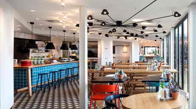 Modern restaurant venue in Zoku Amsterdam, perfect for meetings and events with vibrant decor.