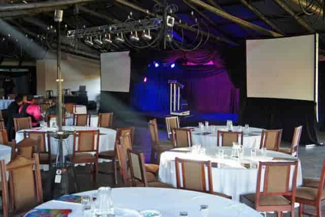 Elegant event space in Trés Jolie for conferences and banquets, with circular tables.