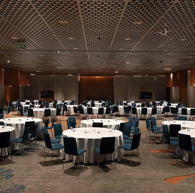 Formal conference venue with round tables and blue chairs at The Houghton Hotel.