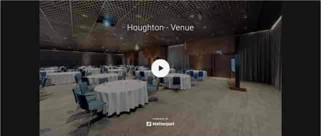 Spacious conference center with round tables and blue chairs at The Houghton Hotel.