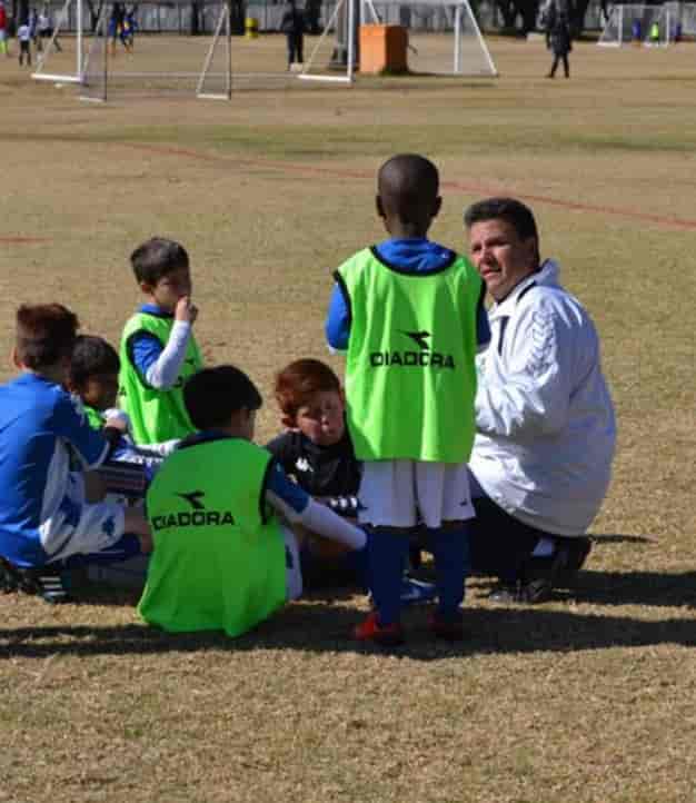 Youth sports team strategy session at The Italian Club promoting teamwork and engagement.
