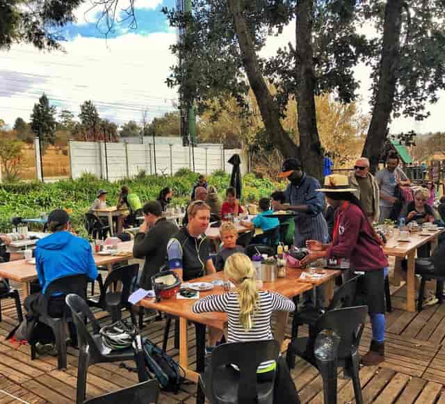 Outdoor dining at Delta Café with long wooden tables, ideal for networking events.