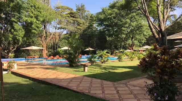 Outdoor event space at Muthaiga Country Club with lush greenery and pool area.