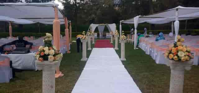 Elegant outdoor wedding venue with floral arrangements and decorated arch.