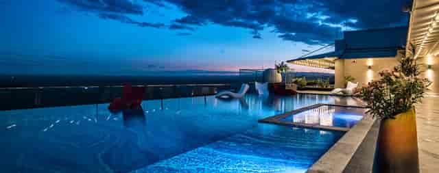 Rooftop bar at Emara Ole Sereni Hotel with infinity pool, perfect for evening events.