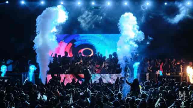 Lively MUZE club event with vibrant lighting and energetic audience enjoying a performance.