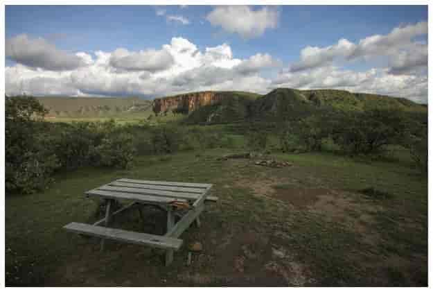 Serene camping ground with rustic picnic table in Hell's Gate National Park, ideal for retreats.