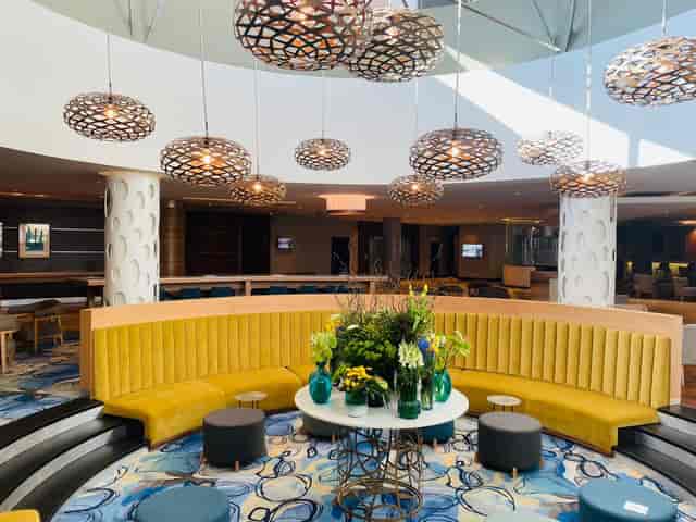 Stylish Southern Sun Rosebank lobby with yellow seating for conferences and networking.