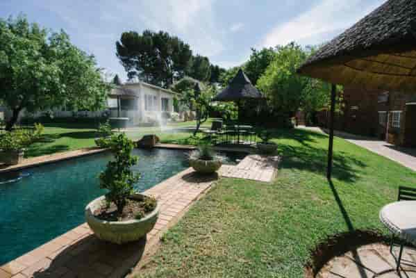 Masai Mara venue with lush greenery and tranquil pool for events and gatherings.