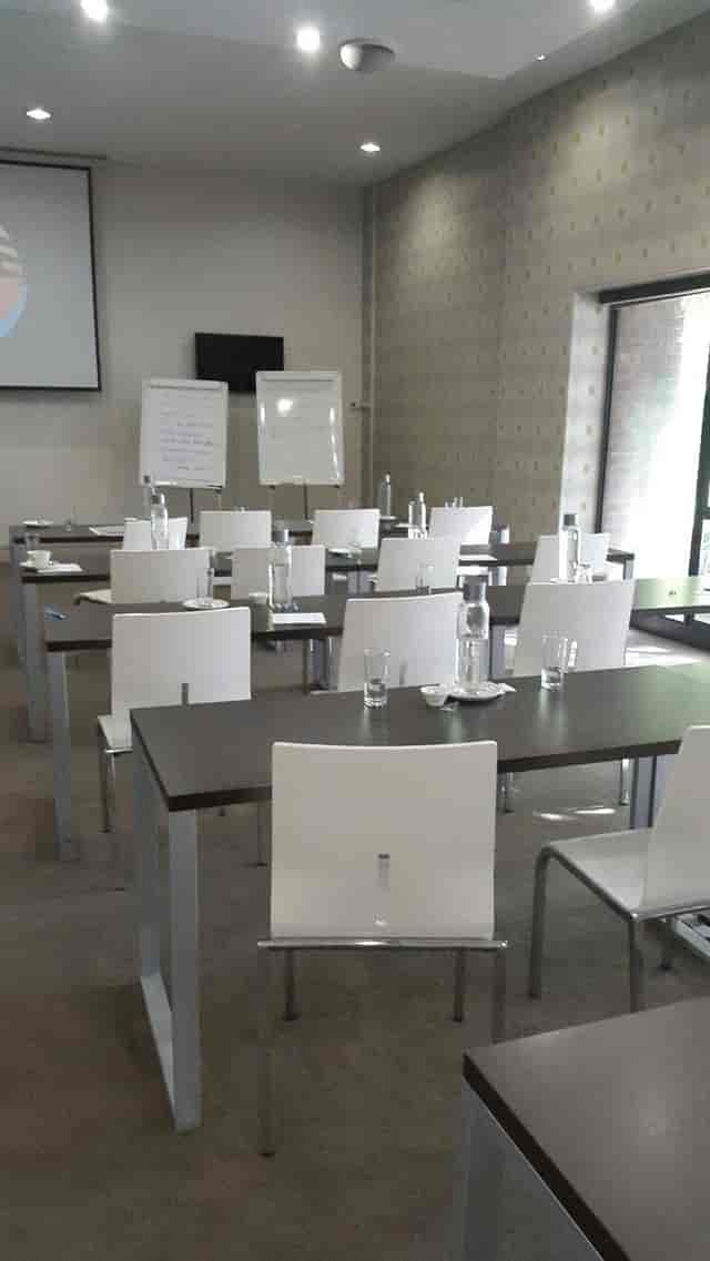 Conference room with rectangular tables set for an engaging corporate meeting event.