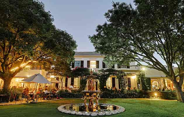Outdoor cabaret venue with charming fountain, perfect for elegant receptions and dinners.