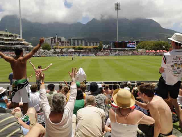 Cricket match at Cape Town Cricket Club with fans and mountain backdrop, ideal for events.