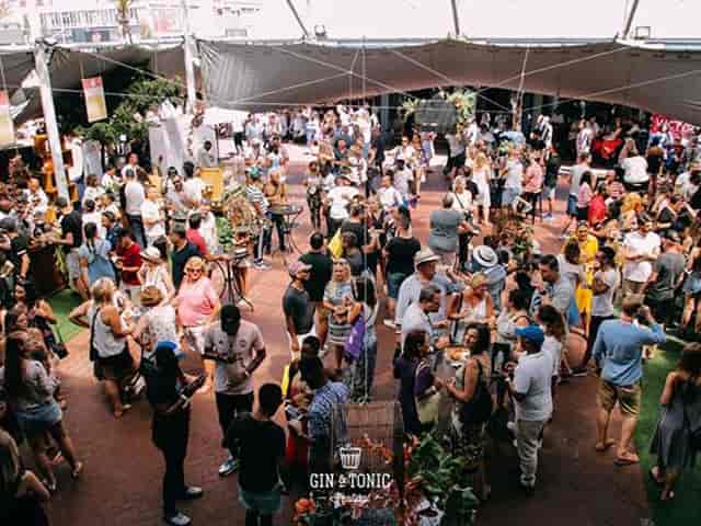 Outdoor conference event at The Old Biscuit Mill with a large crowd under a spacious tent.