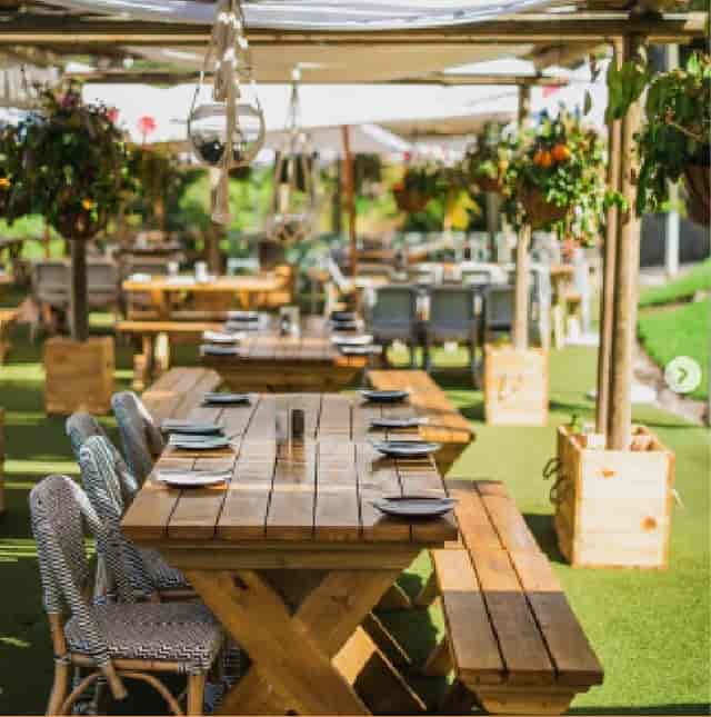 Outdoor dining space at Lawn Big with rustic wooden tables for events and gatherings.