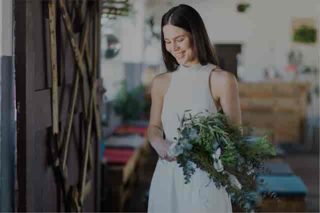 Poised individual in elegant attire at Colorbox Studios outdoor courtyard event.