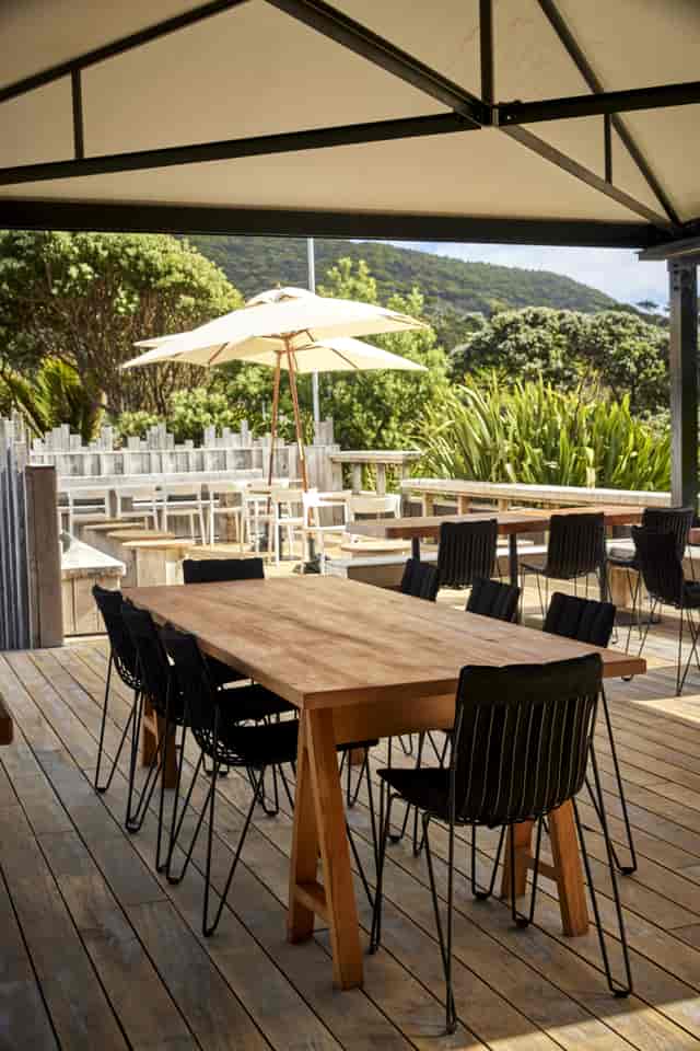 Outdoor dining area with wooden table, modern chairs for al fresco gatherings.