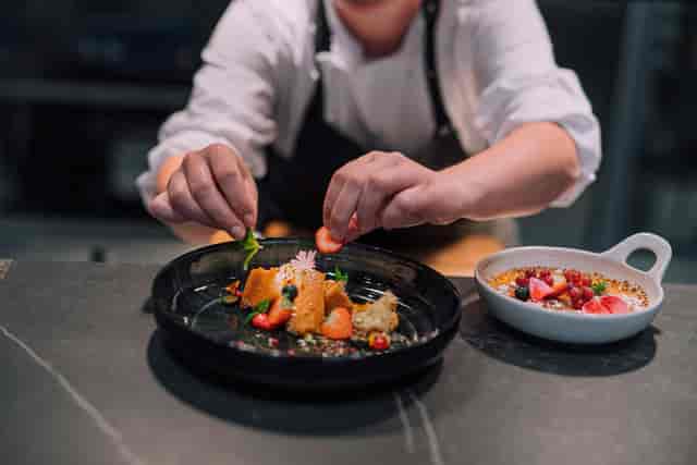 Chef plating a vibrant dish at Bistro ELO, perfect for high-end events and meetings.
