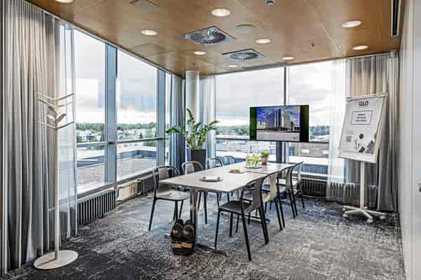 Modern meeting room with large windows, ideal for workshops and team meetings.
