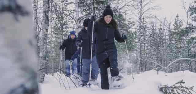Snowshoeing team-building activity at Northern Lights Ranch in winter landscape.
