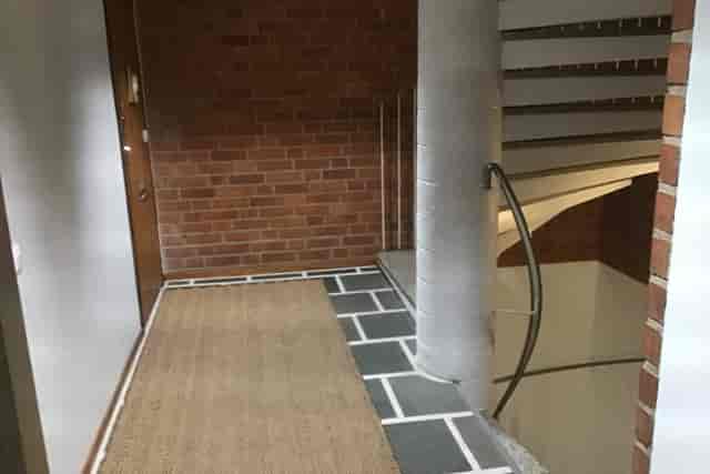Lounge area with brick walls and staircase, perfect for networking events in Munkkiniemi.