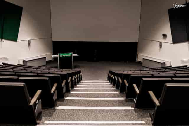 Sleek auditorium setup with tiered seating for corporate events and presentations.