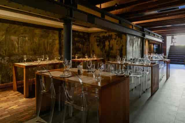 Modern restaurant interior with wooden tables, ideal for private events and intimate dinners.