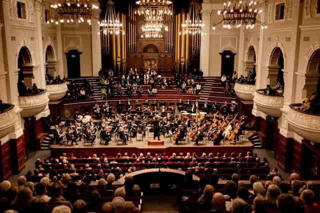 Cape Town Philharmonic Orchestra rehearsal hall with attentive audience for symphony concert.