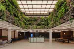 Half Events Space Boardroom at HubHub with lush greenery, ideal for corporate meetings and gatherings.