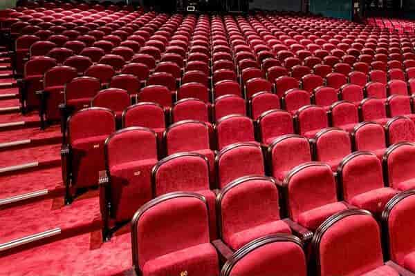 Spacious Savoy Theatre auditorium with red chairs, ideal for conferences and presentations.