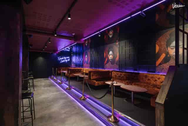Modern NoName Theatre performance area with artistic murals for events and gatherings.