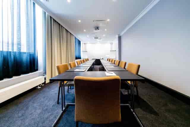 Modern Emmy meeting room with a long conference table, ideal for professional gatherings.