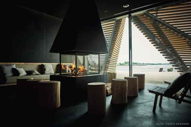 "Modern sauna lounge with central fireplace, ideal for intimate networking events."