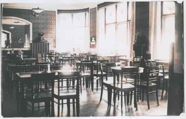 Spacious meeting room with wooden tables in Lehtovaara restaurant for events and workshops.