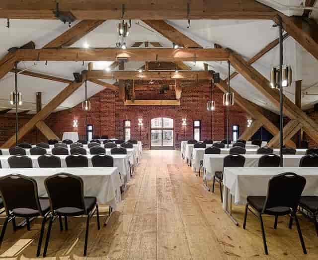Spacious Bankettisali venue with rustic decor for workshops and seminars.