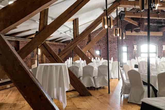 Stylish Bankettisali event space with rustic beams; ideal for weddings or corporate gatherings.