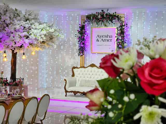 Elegant outdoor wedding venue with floral decor and vintage couch for celebrations.