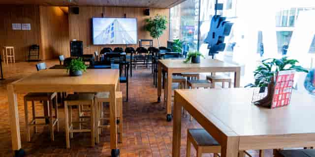 Modern event space in Think Corner with communal tables for workshops and networking.