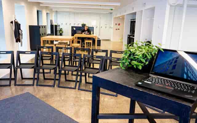 Flexible event space in Think Corner for meetings with rows of black chairs and laptop.