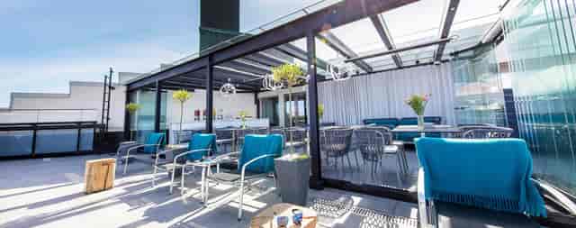Modern rooftop event space at Klaus K Bar & Lounge with sleek glass structures.