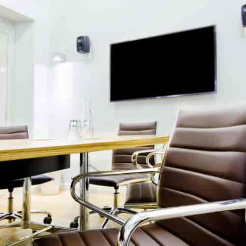 Modern conference room at Klaus K Hotel with sleek table and leather chairs for meetings.