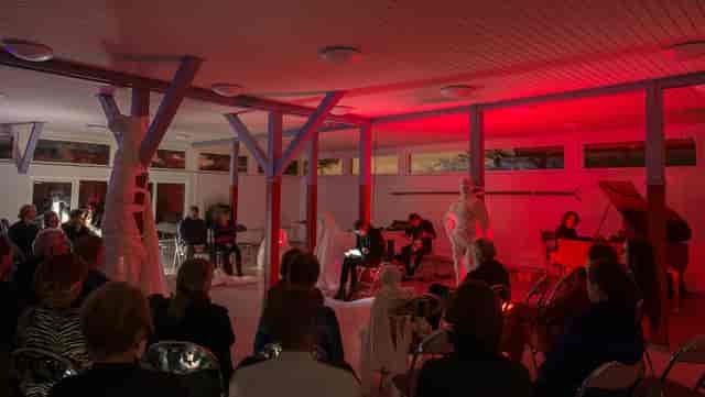 Aula ja keittiö event with red lighting, featuring art and performance in Hietsun Paviljonki.