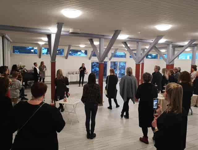 Lively networking event in Hietsun Paviljonki with engaging speaker and natural light.