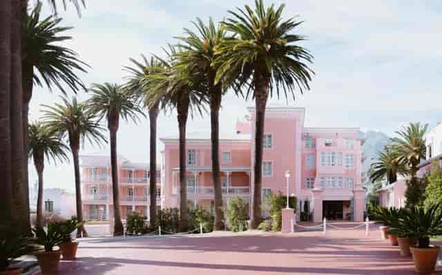 Red Room at Belmond Mount Nelson Hotel, pink venue for events amidst palm trees.