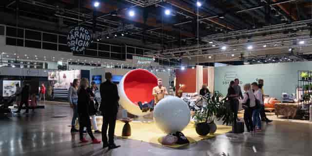 Vibrant Helsinki Design Week exhibition with bold red and white modern seating options.