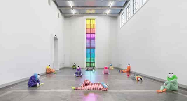 Spacious Kunsthalle Helsinki gallery with colorful figures and stained glass for creative events.