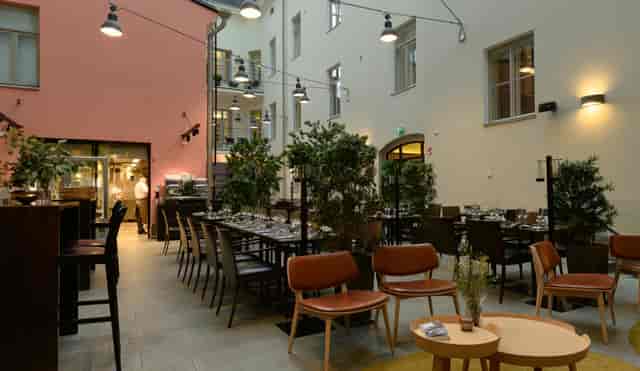 Stylish event space with greenery, perfect for meetings and receptions at Ravintola Olo.